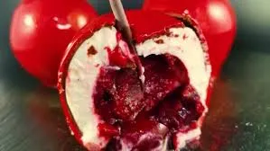 Cherry trompe-l'œil cut open, revealing dark cherry compote inside white mousse